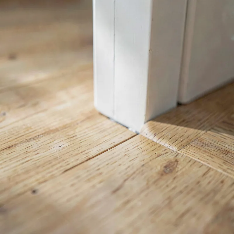 A timber floor meeting a painted door threshold