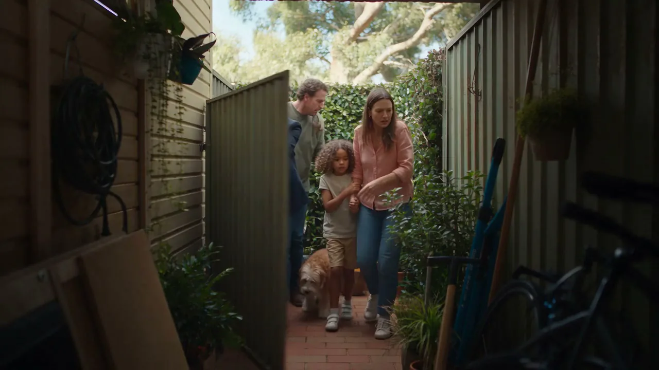 A family and their dog arriving through the side gate for a Saturday open home